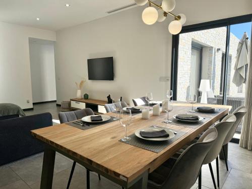 une salle à manger avec une grande table et des chaises en bois dans l'établissement Villa Porto- Vecchio avec piscine 8 pers, à Lecci