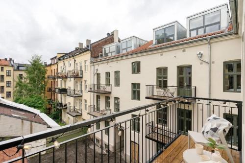 Cet appartement dispose d'un balcon offrant une vue sur les bâtiments. dans l'établissement Dinbnb Apartments Grünerløkka I 2-Bedroom with courtyard access, à Oslo