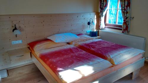 a bedroom with a bed with a wooden head board at Alte Schule in Sankt Oswald