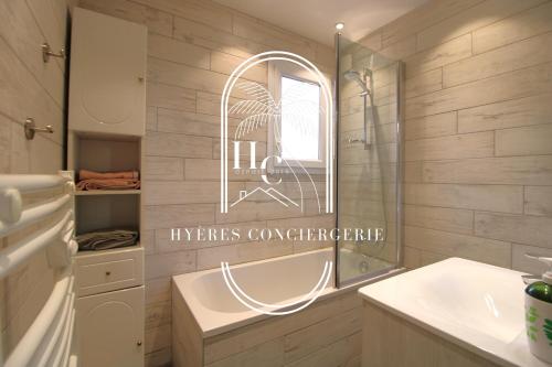 une salle de bain avec une baignoire, un lavabo et un miroir dans l'établissement Duplex au coeur du Port d'Hyères- Plages Parking BY HC, à Hyères