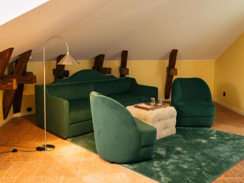 a living room with a green couch and two chairs at Hotel Ruth, WorldHotels Crafted in Stockholm
