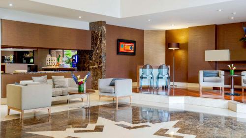 a lobby of a hotel with white chairs and tables at NH Collection Bogota Andino Royal in Bogotá