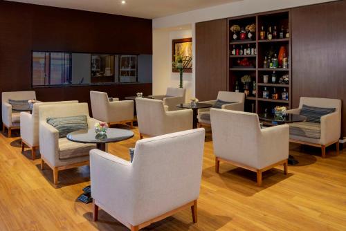 a restaurant with white chairs and tables and shelves at NH Collection Bogota Andino Royal in Bogotá
