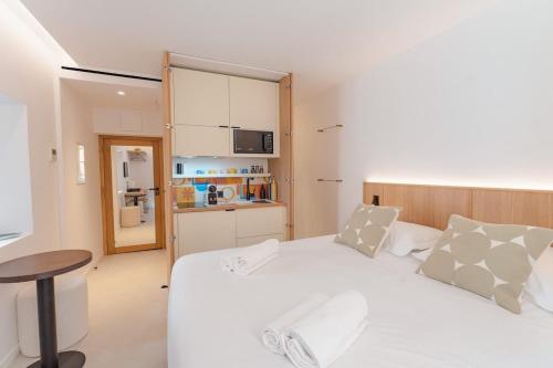 Cet appartement comprend une chambre avec un lit blanc et une cuisine. dans l'établissement The Bell Tower l In Old Village l Shellter Rentals, à Saint-Tropez