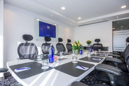 a conference room with a long table and chairs at NH Bogota Urban 26 Royal in Bogotá