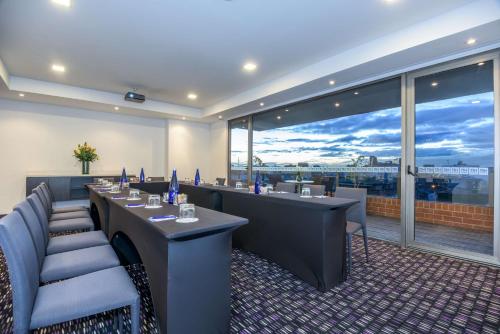 a restaurant with tables and chairs and a large window at NH Bogota Urban 26 Royal in Bogotá