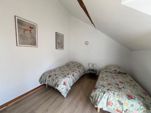 une chambre avec deux lits dans un grenier dans l'établissement Chez Riton - Château de Thésée, à Thésée