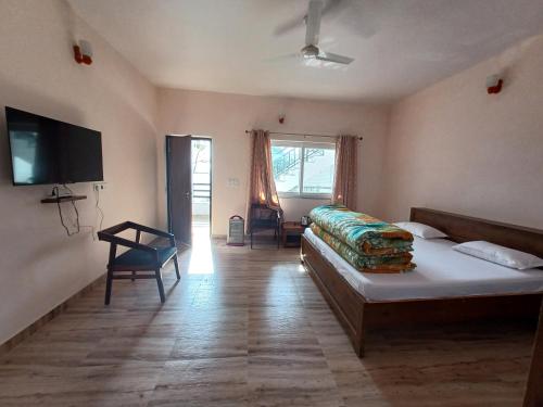 a bedroom with a bed and a flat screen tv at Johaar Retreat, Bhimtal in Bhowāli
