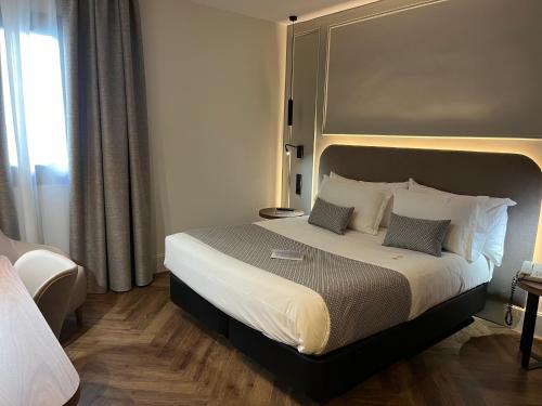 a bedroom with a large bed with a large headboard at Silken Rona Dalba in Salamanca