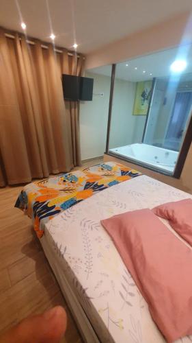 a bed sitting in a room with a window at Pousada chc in Praia Grande
