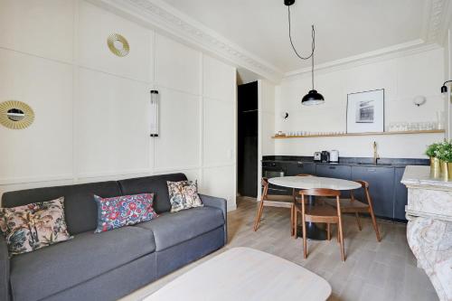 un salon avec un canapé et une table dans l'établissement Pick A Flat's Apartments in Madeleine - Rue Tronchet, à Paris