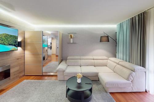 un salon avec un canapé blanc et une télévision dans l'établissement Cozy Apt with Balcony - 5 min to the Beach, à Nice