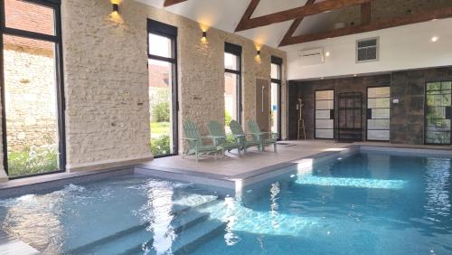 - une piscine dans une maison avec fenêtres dans l'établissement Gite du Four à Pain 4* - Le Domaine des Cyclamens, à Verneuil-sur-Indre