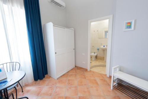 a room with a white cabinet and a table and a bathroom at Artis Mare in Pozzuoli