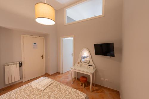a bedroom with a bed and a mirror and a tv at Artis Mare in Pozzuoli