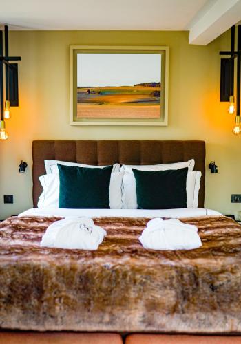 a bedroom with a large bed with two towels on it at Hôtel-Restaurant Bel Ami in Pacy-sur-Eure