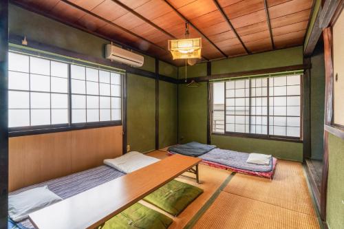 a room with two beds and two windows at ゲストハウスのどけや in Mima
