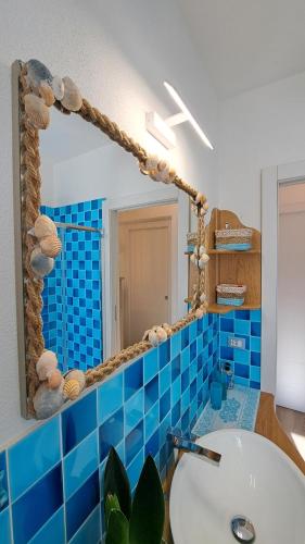 a bathroom with a mirror and a sink at Harry's House San Teodoro con piscina privata in San Teodoro