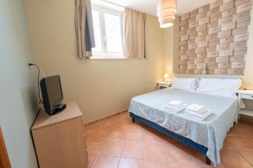 a bedroom with a bed and a tv in it at Artis Mare in Pozzuoli