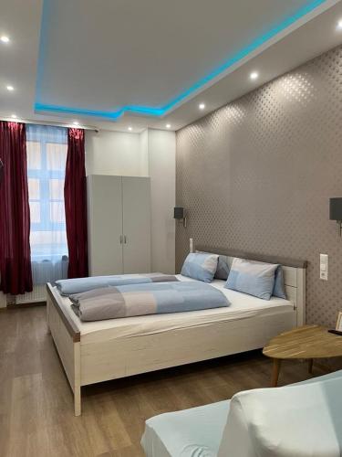 a bedroom with a large bed with a blue ceiling at Trang Hotel Rastatt in Rastatt