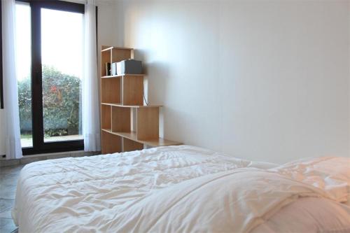 un lit blanc dans une chambre avec une fenêtre dans l'établissement Appt 2 pièces LA ROCHELLE - LR440-003, à La Rochelle