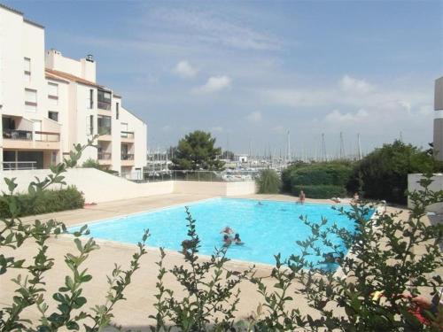une grande piscine bleue à côté d'un immeuble dans l'établissement Appt 2 pièces LA ROCHELLE - LR440-003, à La Rochelle