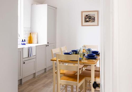 a kitchen with a wooden table and chairs in a kitchen at The Bakers House in Elie