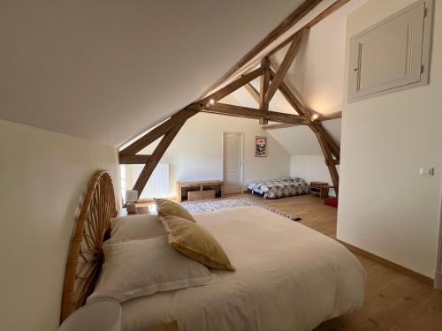 une chambre avec un grand lit dans un grenier dans l'établissement La Closerie – Château de Thésée, à Thésée