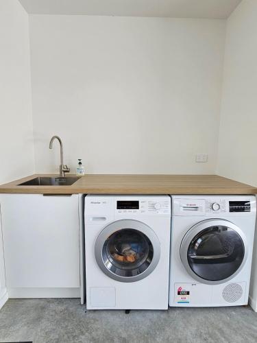 a kitchen with a washing machine and a sink at Family home, Game Zone & Outdoor Fireplace- Sleeps 10 in New Plymouth