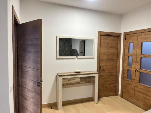 a room with two wooden doors and a table at Apartamentos La Fuente in Almodóvar del Río