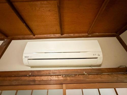 a white printer sitting on top of a shelf at 窓際から海と鉄道が見える宿 サウナ プロジェクター カラオケ完備 トリックマーメイド in Ito
