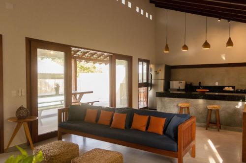 ein Wohnzimmer mit Couch und Küche in der Unterkunft Casa Aroeira em Barra Grande - Casa principal in Barra Grande