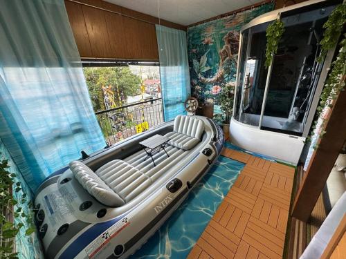 a room with a large inflatable boat on the floor at 窓際から海と鉄道が見える宿 サウナ プロジェクター カラオケ完備 トリックマーメイド in Ito