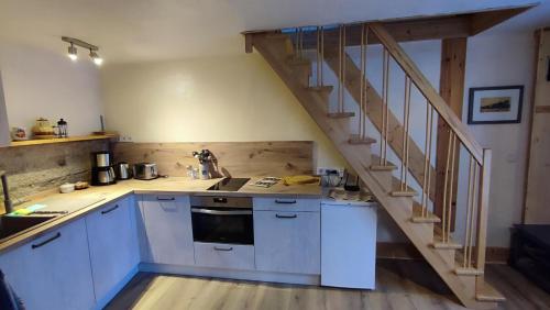 a kitchen with white cabinets and a staircase at Hainich-Zeit in Eigenrieden