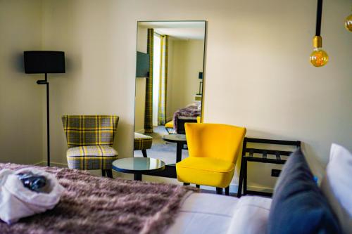 a bedroom with a bed and a chair and a mirror at Hôtel-Restaurant Bel Ami in Pacy-sur-Eure