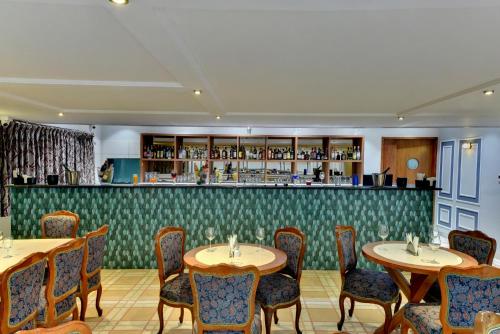 a restaurant with tables and chairs and a bar at The Luxant Hotel in Bengaluru
