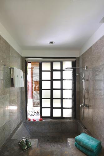 a bathroom with a shower and a glass door at Banyan Tree Bintan in Lagoi