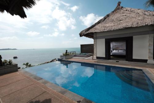 a swimming pool in front of a resort with the ocean at Banyan Tree Bintan in Lagoi