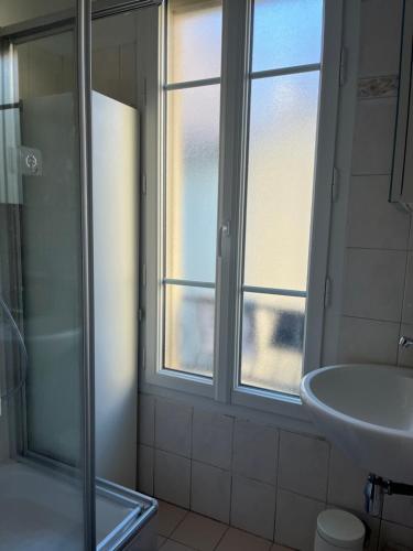 une salle de bain avec une douche et un lavabo et une fenêtre dans l'établissement Cozy pavillon quartier Laplace, Maison des examens, à Arcueil