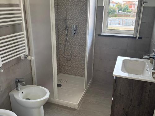 a bathroom with a shower and a toilet and a sink at Casa Vacanza A Due Passi Dal Mare-Relax E Confort Vicino L'aeroporto Di Fiumicino in Focene