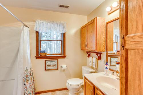 a bathroom with a toilet and a sink and a window at Charming Apartment with Yard and Beautiful Gardens! in Manheim