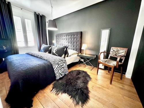 une chambre avec un lit et une chaise dans l'établissement ApartHotel Riviera - Balcon du Serrurier - Old Town - Promenade des Anglais, à Nice