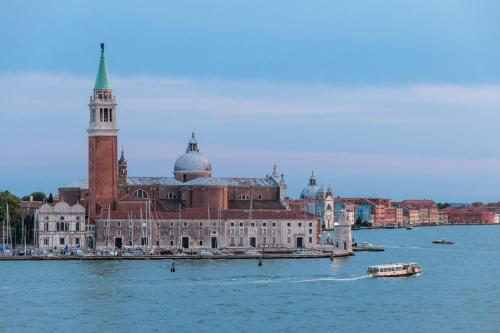 a large building with a clock tower on the water at Hotel Gabrielli Venezia - Starhotels Collezione in Venice