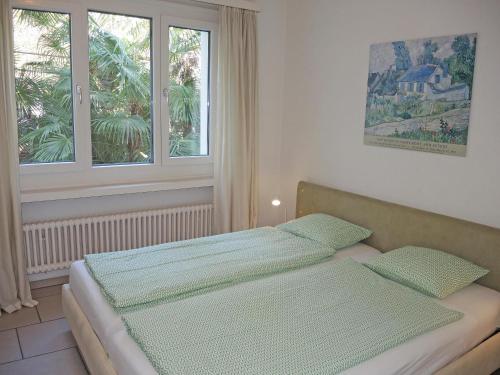 a bedroom with two beds and two windows at Fiore Rosa by Fewotessin in Ascona