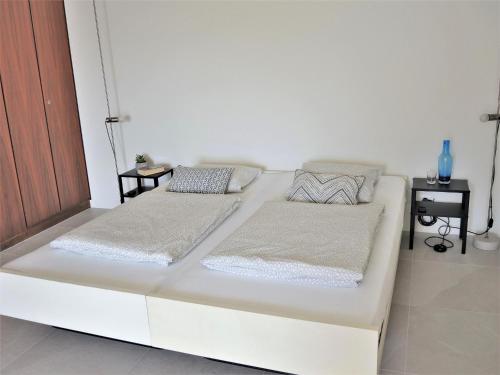 a white bed with two pillows on it in a room at Bellavista by Fewotessin in Locarno