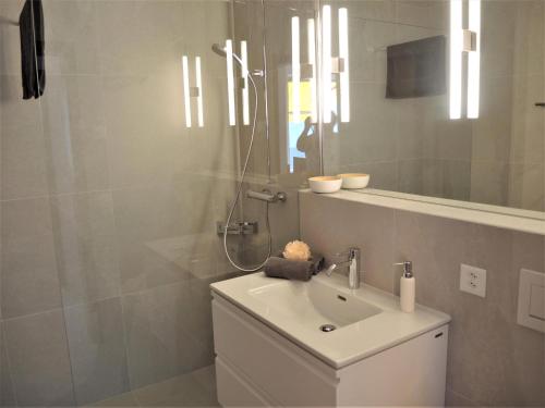a white bathroom with a sink and a shower at Bellavista by Fewotessin in Locarno