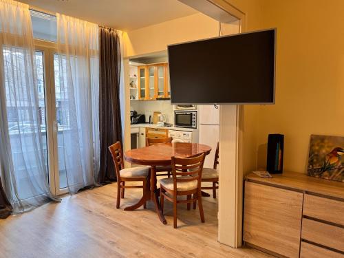 Una cocina y un comedor con una mesa y un televisor. en Cozy Central Apartment Steps from Everything!, en Varna