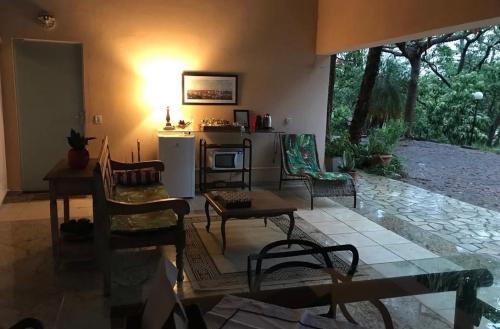 a living room with a table and chairs and a kitchen at Loft em chácara Espírito Santo in Espirito Santo Do Pinhal