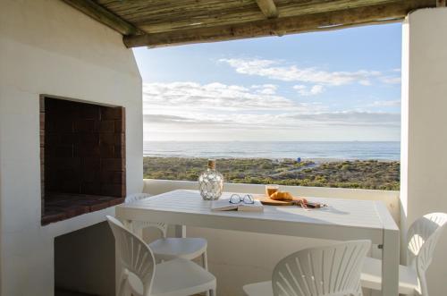 a dining room with a table and a view of the ocean at Bella La Vita Beachfront Villa in Velddrif