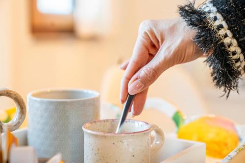a person stirring a cup of coffee with a spoon at Haus Frey in Altaussee
